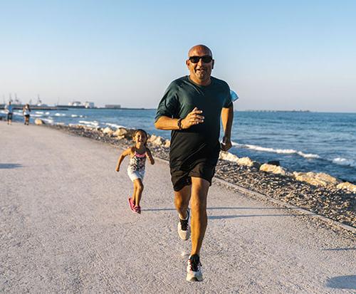 父亲和女儿在海滩上奔跑