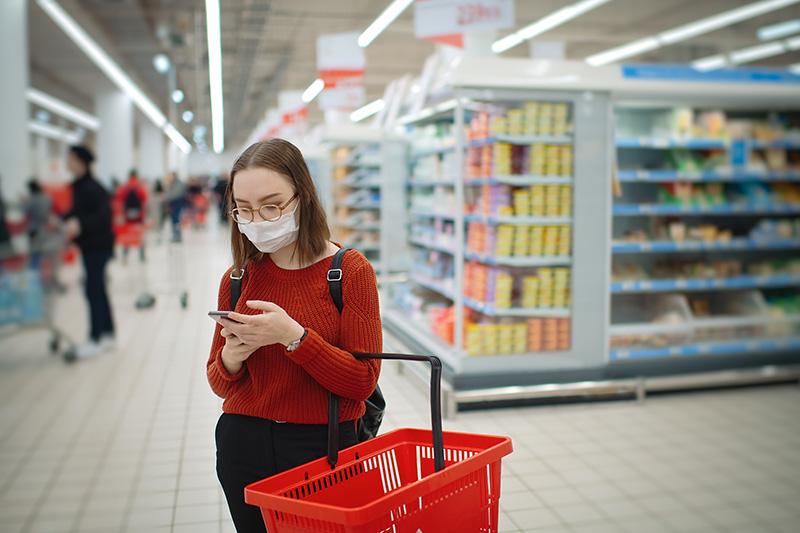 女购物者在购物时阅读心脏检查认证的产品清单