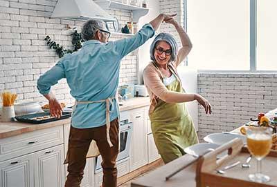 快乐的老夫妻一边在家做饭一边跳舞